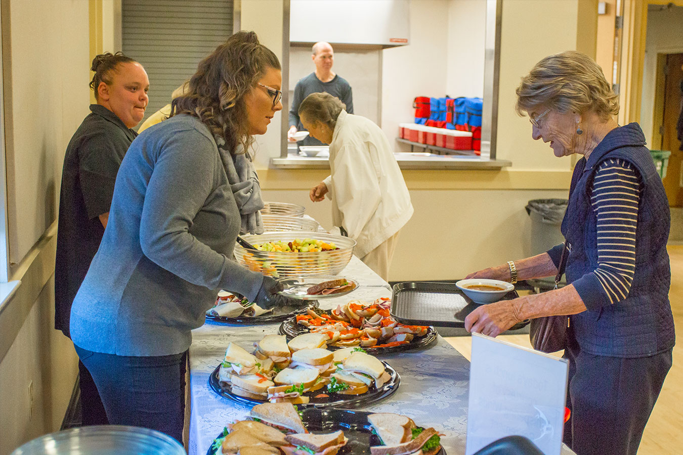 A volunteer serving food at a social activity at Bend Senior Center.