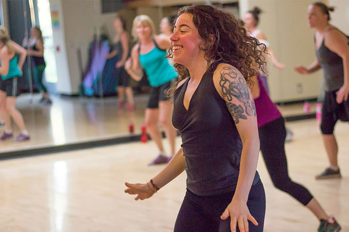 A woman leads a dancing fitness class.