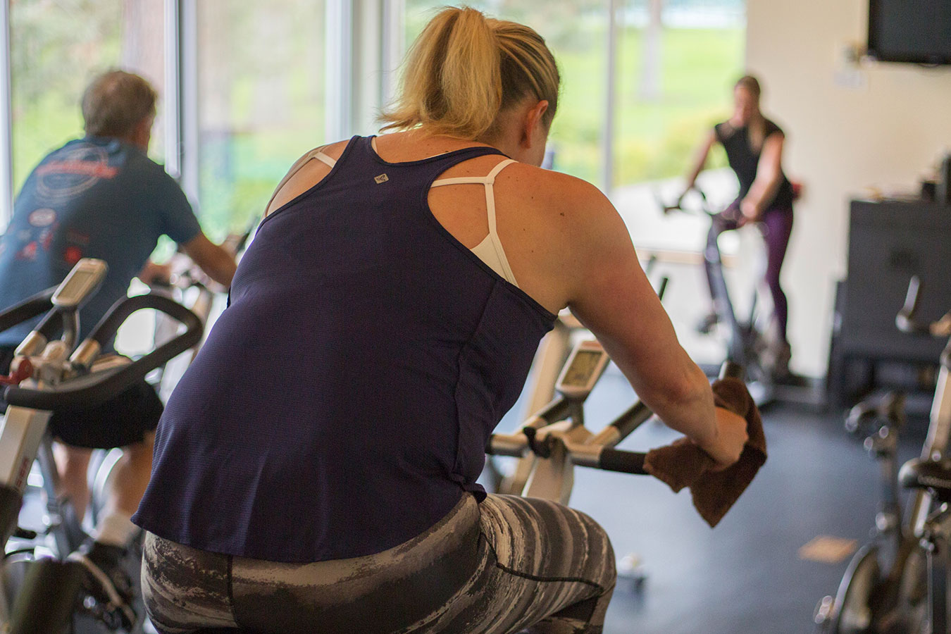 A biking fitness classfeaturing a woman in a workout.