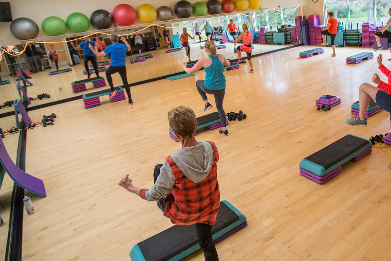 Several patrons are moving in a fitness class.