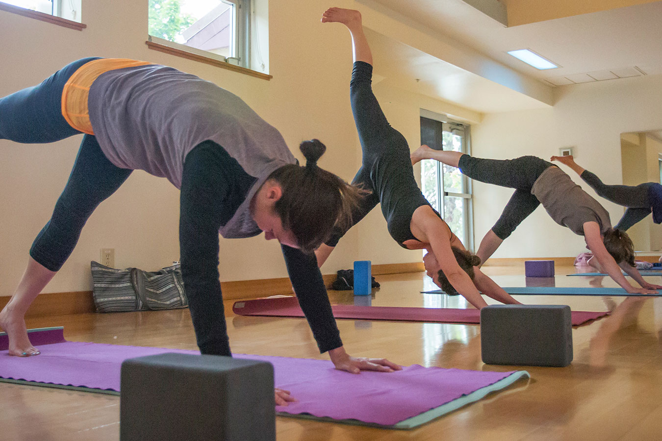 Several patrons holding yoga poses during a fitness class.