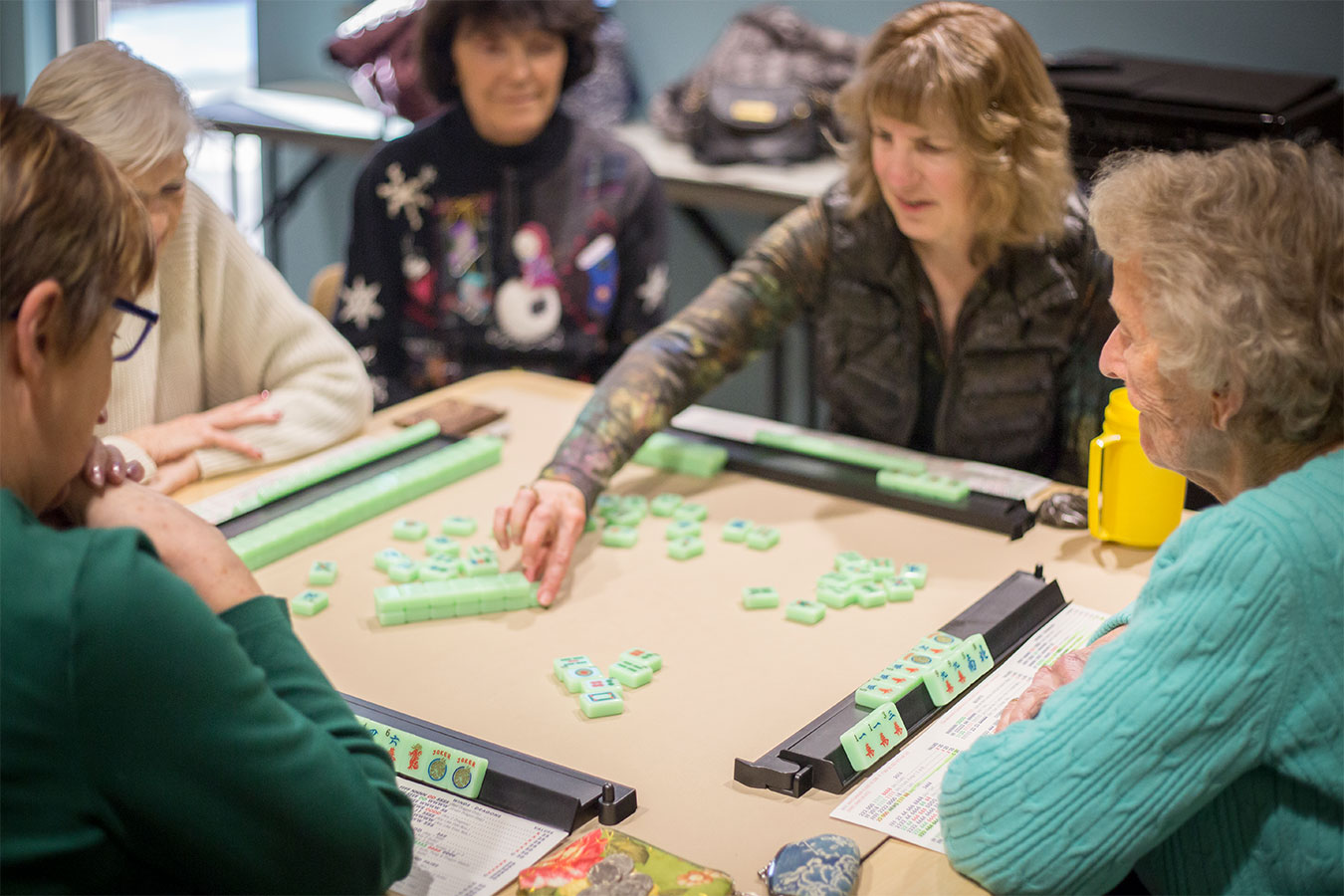 Group of adults playing a tabletop game at the Bend Senior Center