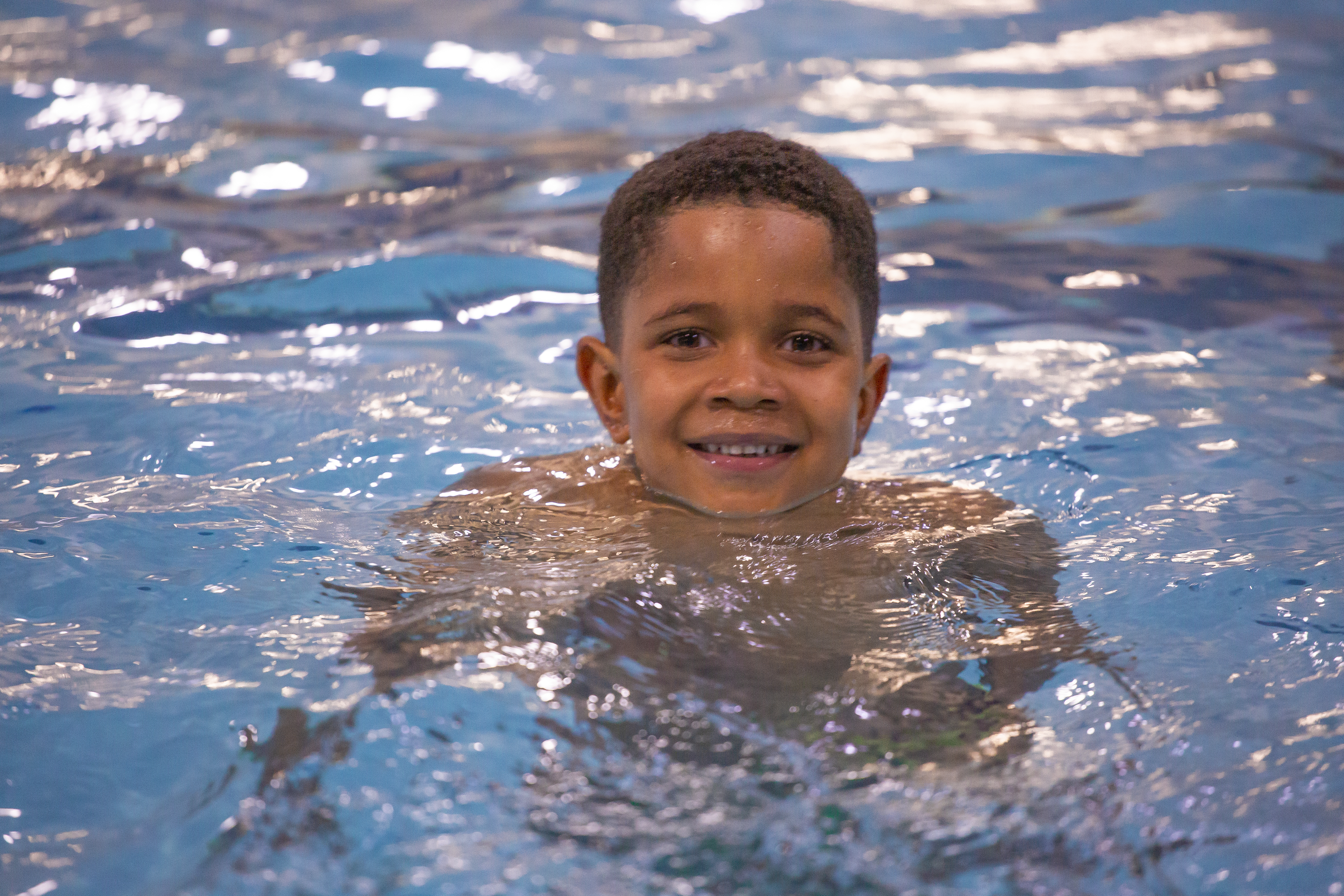 Child smiling while floating in a Juniper pool