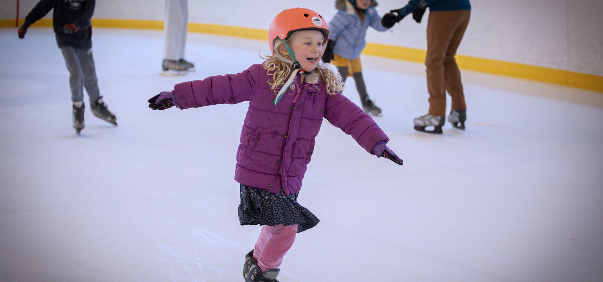 A young girl smiles as she ice skates at the Pavilion during open skate.