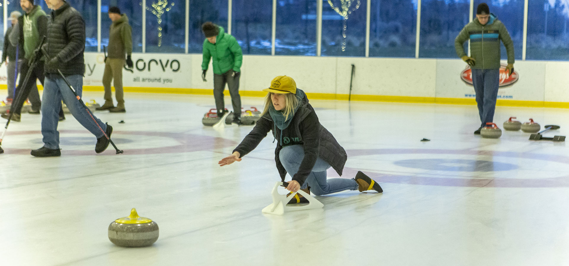 Woman on the ice releases a curling stone at the Pavilion.