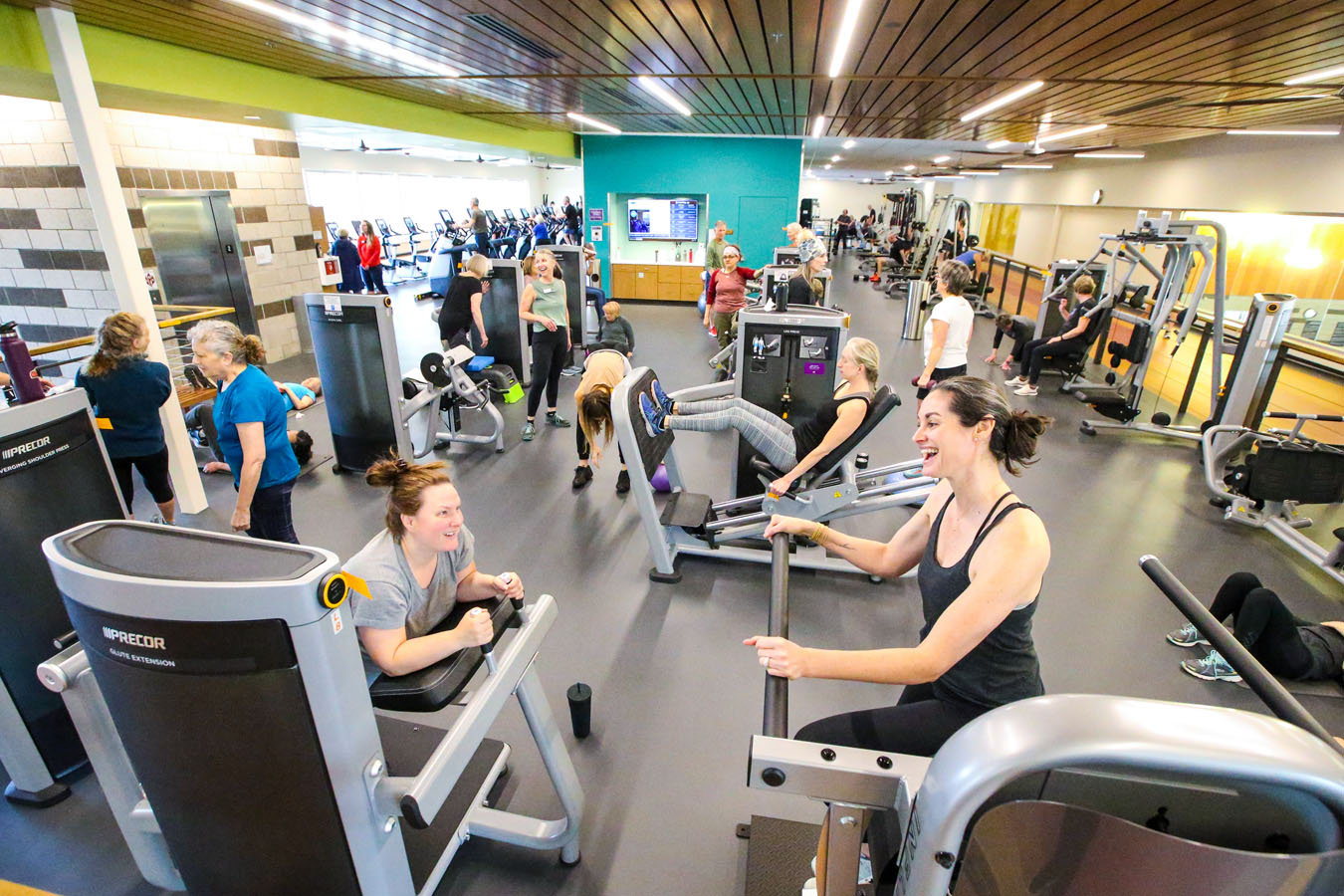 A busy fitness center being used by many patrons.