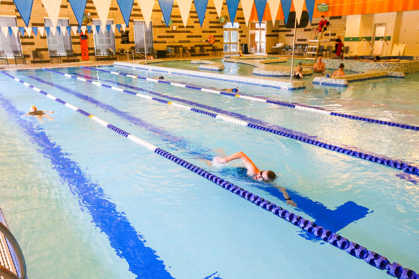 Photo of Larkspur's pools with several lap swimmers and the current in the background