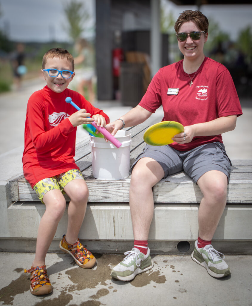 Child and recreation leader handling play equipment