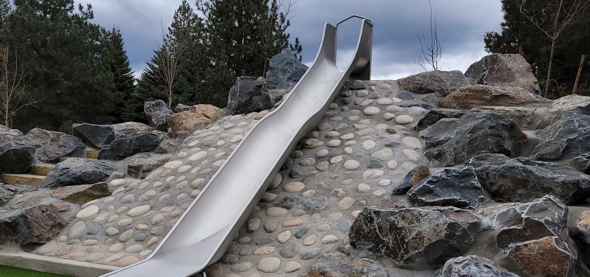 Photograph of metal slide built into the landscape of Little Fawn Park.