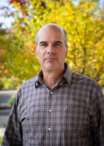 Photograph of Nathan Hovekamp looking directly forward with trees in the background.