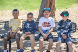 Four children sitting on a bench at BPRD's Kids Inc. program.